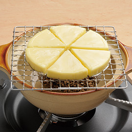 ❶アルミ箔カップにスモークチップ大さじ４、ピート大さじ１を入れて混ぜ、土鍋に入れる。網の上にチーズをおいておく。